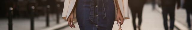 Robe en jean bleu coupe droite mi-longue avec col chemise, ceinture à la taille et boutonnage devant.