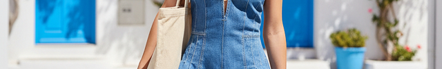 Combinaison short en jean bleu clair sans manches à bretelles larges, coupe ajustée au buste et évasée aux jambes.