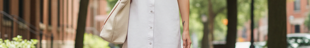 Robe chemise en denim blanc, coupe droite courte, sans manches, à volants et boutonnage intégral sur le devant.