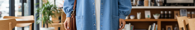 Robe chemise oversize en jean bleu clair, coupe ample, manches longues bouffantes, longueur mi-cuisse effilochée.