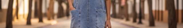 Robe en jean bleu clair courte à coupe droite légèrement trapèze, encolure en V et poches frontales plaquées.