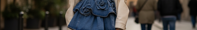 Robe en jean bleu courte évasée sans manches, buste ajusté et ornements floraux en relief sur la jupe.