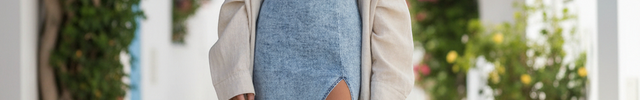 Robe en jean bleu délavé midi bustier à coupe ajustée, fente cuisse et fines bretelles.
