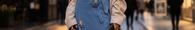 Robe longue en denim bleu clair sans manches, coupe droite avec fente haute et découpes ceinturées par liens en jean.