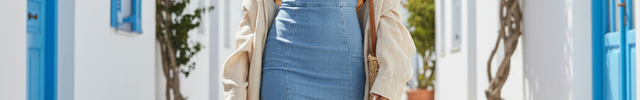 Robe en jean bleu clair mi-longue, coupe ajustée, sans manches, col en V et fente latérale jusqu’au genou.